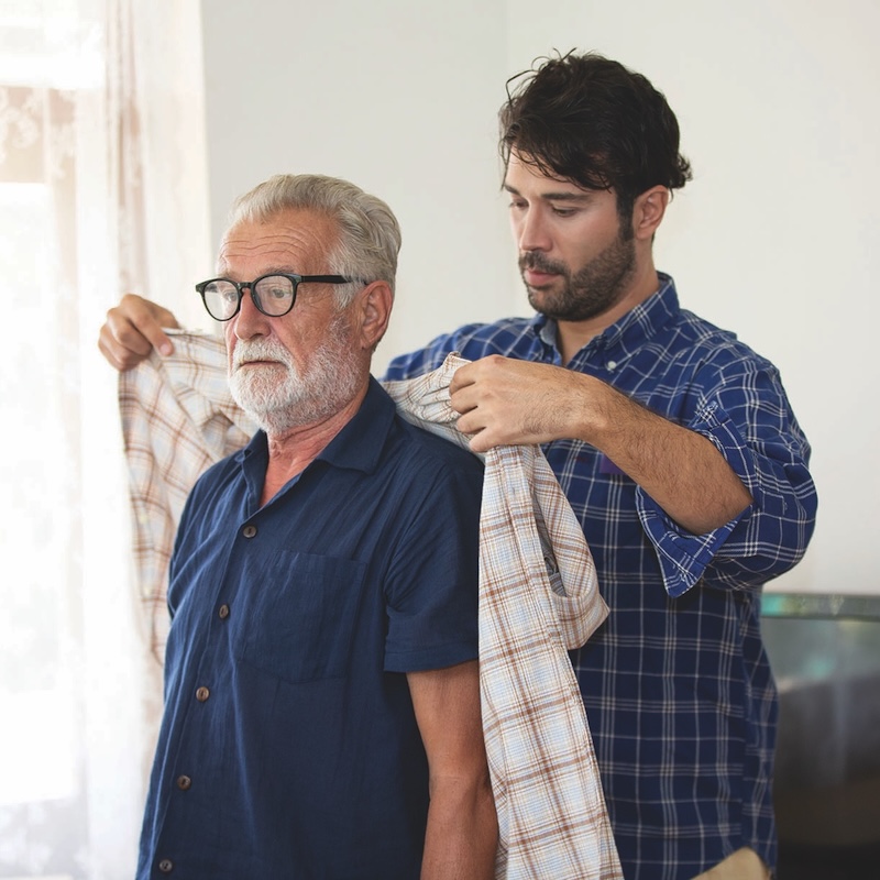 Hipster man taking care about his elderly father in house.