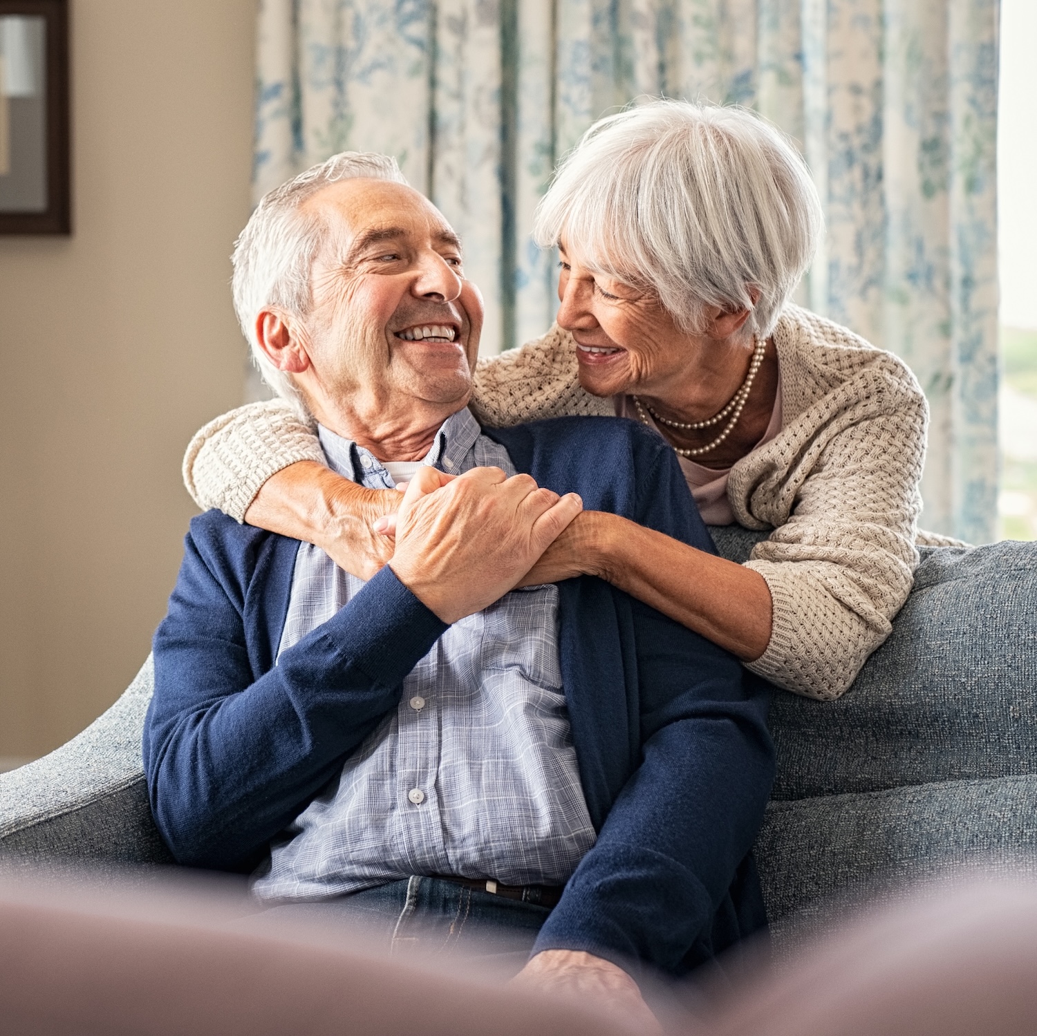Senior couple hugging and having fun at home